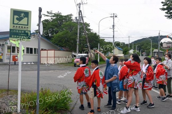 久野さん（左から３人目）から海岸エリアの防災について説明を受ける児童