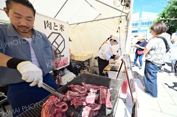 十勝産牛肉を使った丼など、出店ブースは地場産メニューをワンコイン（５００円以下）で提供。暑さの中、絶えず調理する担当者ら（１日）