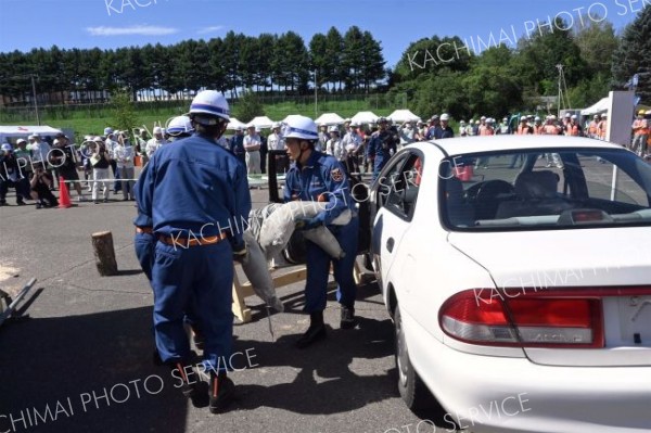 倒壊した工事現場で鋼材の下敷きになった車両の中から負傷者に見立てたダミー人形を救出する消防団員ら