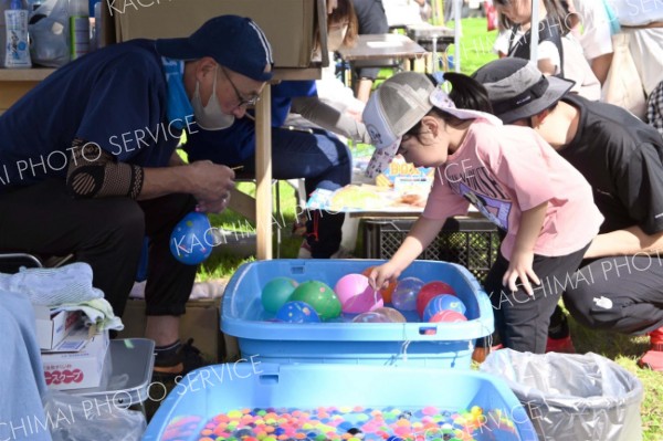 ヨーヨー釣りを楽しむ家族連れ