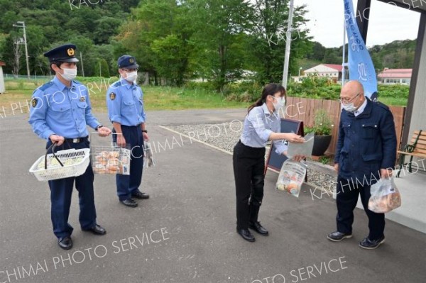 来店客に啓発用のオリジナルパンを配布する広尾署員