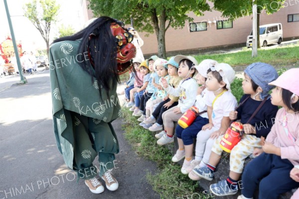 獅子舞を怖がる子どもたち（２４日午前１０時２０分ごろ、助川かおる通信員）