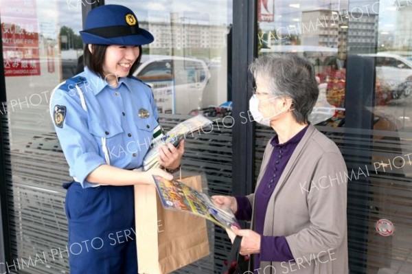 買い物客に啓発グッズを手渡す帯広署員