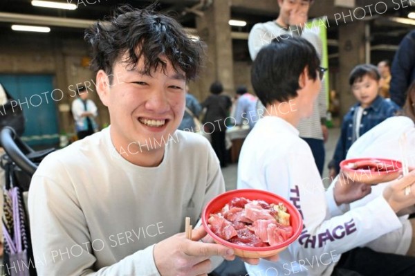 限定５００食の「生本マグロ丼」を手にする買い物客（２９日午前９時５０分ごろ、須貝拓也撮影）