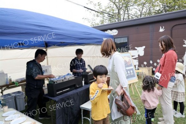 水素グリルで調理した鹿追チョウザメの切り身や牛肉などを試食する来場者。会場では水素のさまざまな活用が実演された