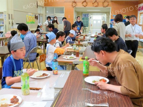 青年部員と食事を楽しむ児童ら