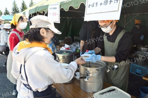 飲食ブースの「かぼちゃ団子汁」を受け取る客