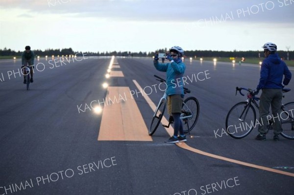 ２３日の「ランウェイサイクル」中、滑走路の途中で記念写真を撮る参加者（とかち帯広空港）