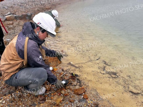 青沼の水質を調査する専門家。青く見える水の色は、沼の底の白色の泥も影響している可能性がある