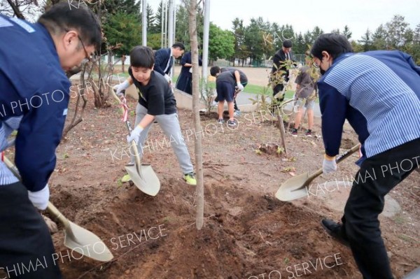 植樹する児童とローソン関係者