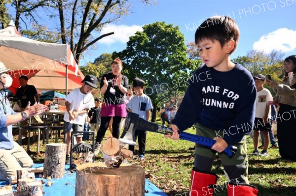 まき割りに挑戦する子ども。狙いを定めおのを振り下ろしていた