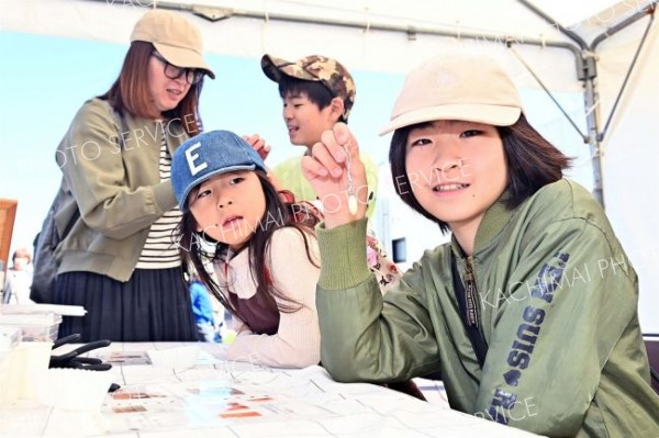 豆を使ったワークショップでキーホルダーを制作する親子連れ