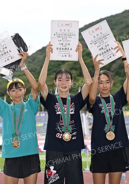 Ｕ１６女子１０００メートルで準優勝し、表彰台で賞状を掲げる（中央、足寄中２年）