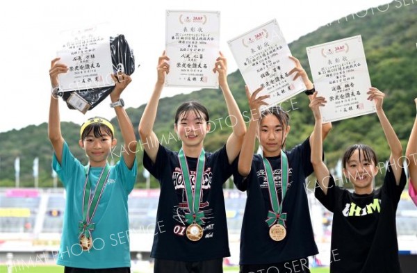 Ｕ１６女子１０００メートルで２位に入賞し、表彰台で賞状を掲げポーズをとる