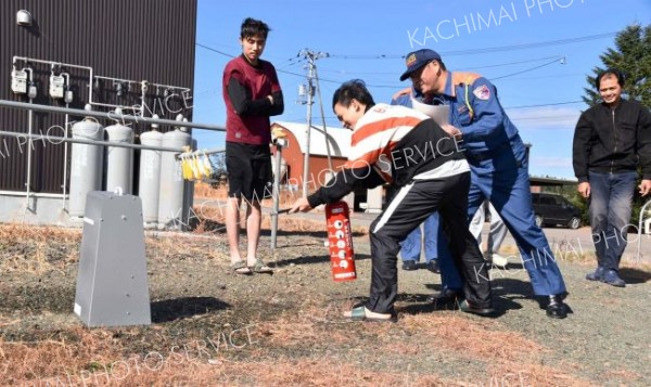 陸別消防署員の指導の下、消火器を扱う町内居住の外国籍就労者