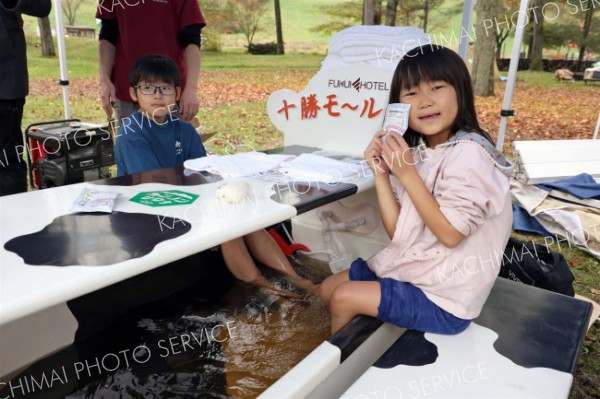 ふく井ホテルのモール温泉にほっこり―。雨も降り冷え込む会場で足湯を楽しむ子どもたち