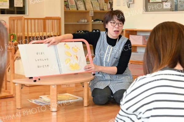 大型絵本「くだものどうぞ」を親子に読み聞かせする主任補