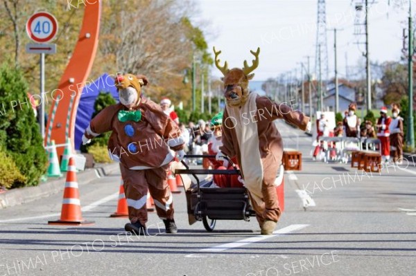 坂道も何のその、サンタとトナカイの仮装で奮闘するソリ大会の参加者（石原秀樹通信員撮影）