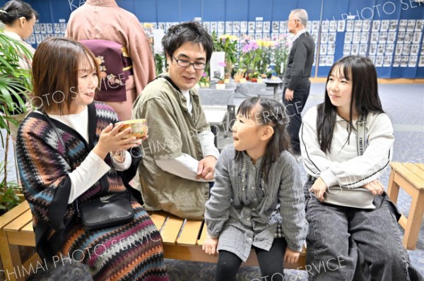 会場の一角に設けられた野点コーナーで抹茶を味わう親子連れ