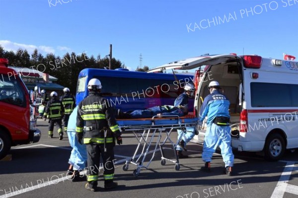 道東道音更帯広ＩＣ近くでバスの横転事故発生を想定し、傷病者を搬送する参加者ら