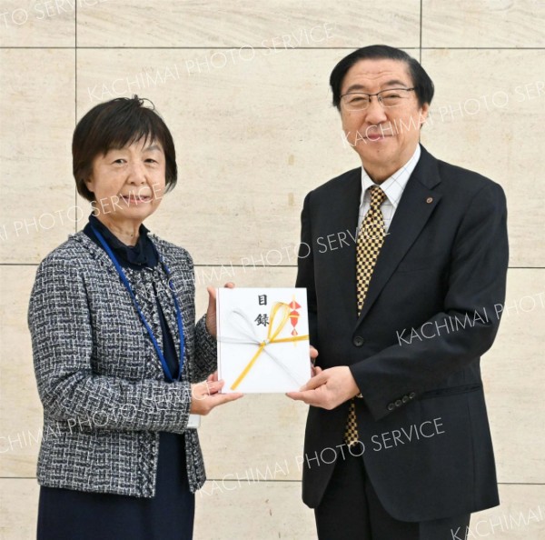 目録を手渡す帯広美術館振興会の川田会長（右）と北海道立帯広美術館ボランティア「しらかばの会」の長島欣子会長