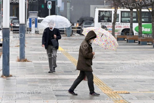 雨の中、足早に歩く通行人（２２日午前９時１５分ごろ、ＪＲ帯広駅前で。須貝拓也撮影）