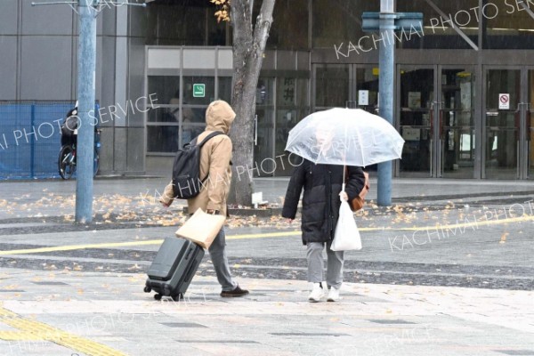 雨の中、足早に歩く通行人（２２日午前９時１５分ごろ、ＪＲ帯広駅前で。須貝拓也撮影）