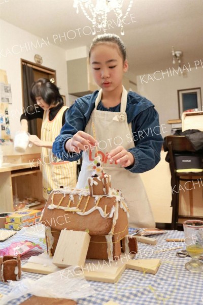 お菓子の家を組み立てる参加者たち