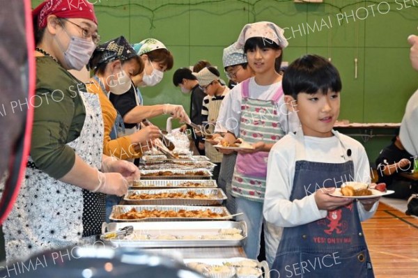 完成した餅を受け取る児童ら（金野和彦撮影）