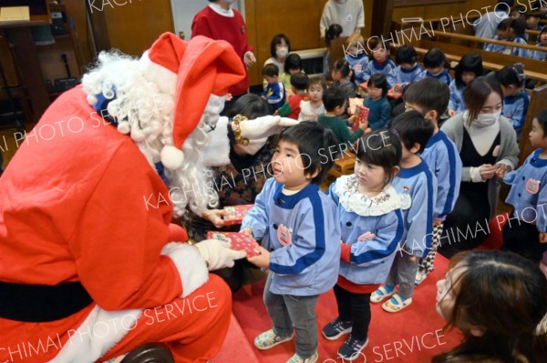 サンタさんから笑顔でプレゼントを受け取る園児（１６日午前１１時２０分ごろ）