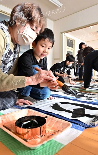 大人に教わりながら書き初めをする児童（４日午前１０時５０分ごろ、塩原真撮影）