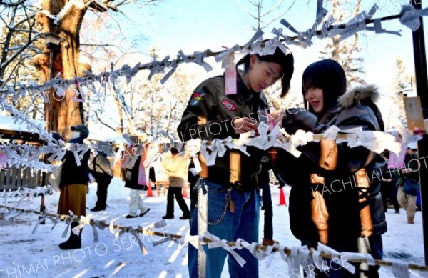 今年の運勢は－。おみくじを見せ合うカップル（１日、帯廣神社で）