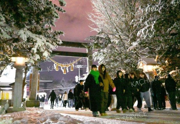 ３１日に積雪した帯広市内。木々の枝に付着した参道を歩く参拝客（帯廣神社で。金野和彦撮影）