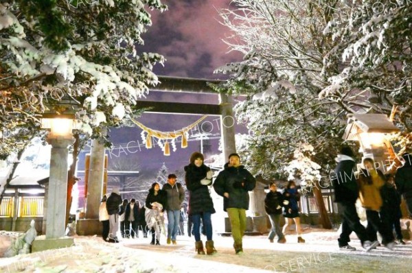 ３１日に積雪した帯広市内。木々の枝に付着した参道を歩く参拝客（帯廣神社で。金野和彦撮影）