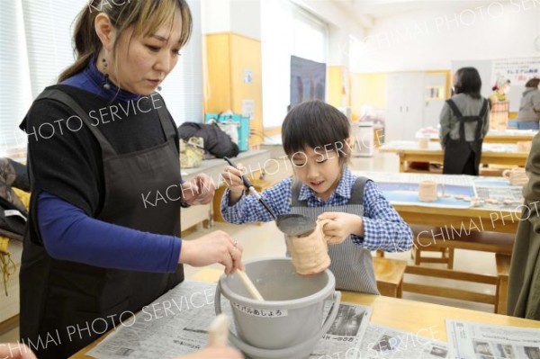 自作した素焼きの器に色付けする参加者