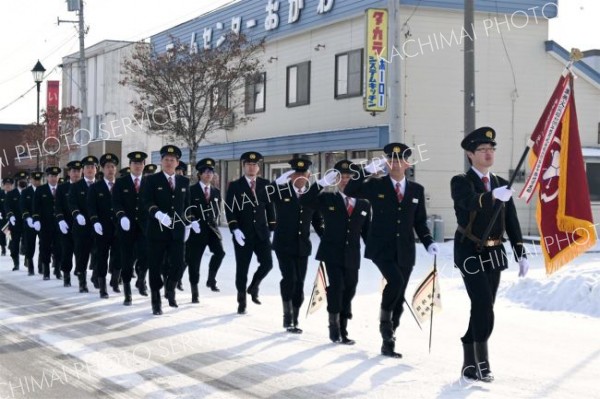 村内の市街地を分列行進する団員たち