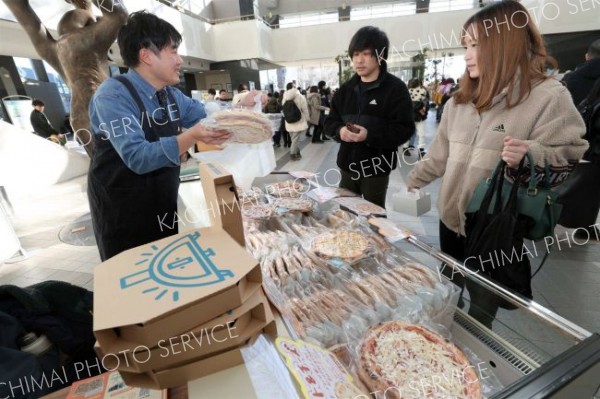 商品を選ぶ来場者ら（１８日午前１１時ごろ、助川かおる通信員撮影）