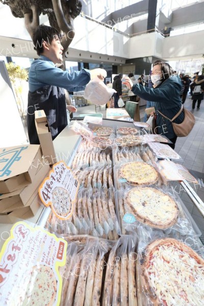 ピザを買う来場者（１８日午前１０時４５分ごろ、助川かおる通信員撮影）