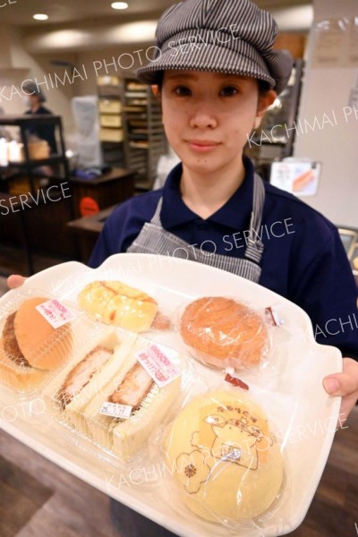 店舗マスコットがプリントされた店限定のクリームパン（右下）などをＰＲするボヌールマスヤのスタッフ