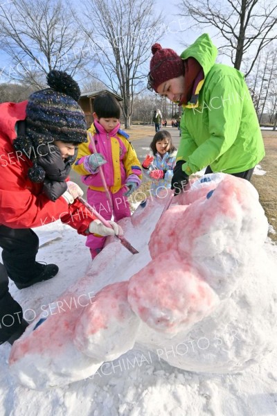 雪だるコンテストで万博キャラクターの「ミャクミャク」を制作する親子連れ（１９日午前１０時半ごろ、塩原真撮影）