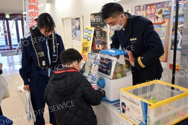 海上保安庁ガチャガチャを回し、カプセルを手に取る子ども