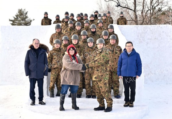 制作した滑り台の引き渡しを受け握手する大宮実行委員長（手前左）と山内制作隊長（手前右）