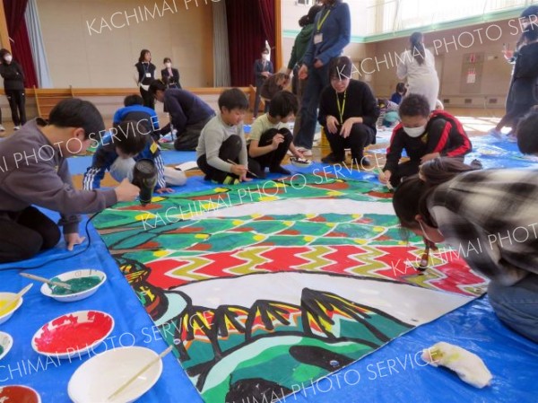 美大生のアドバイスを受けながら運動会の看板を作る上札内小の児童ら