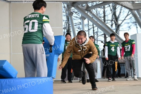 帯広畜産大学のアメフト部員に勢いよくタックルする観客（１日、須貝拓也撮影）