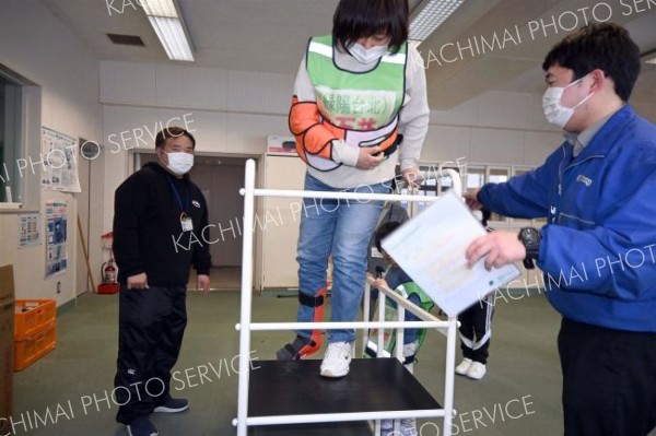 要配慮者移乗訓練で足が不自由な状態を疑似体験する参加者（８日、下音更小学校）