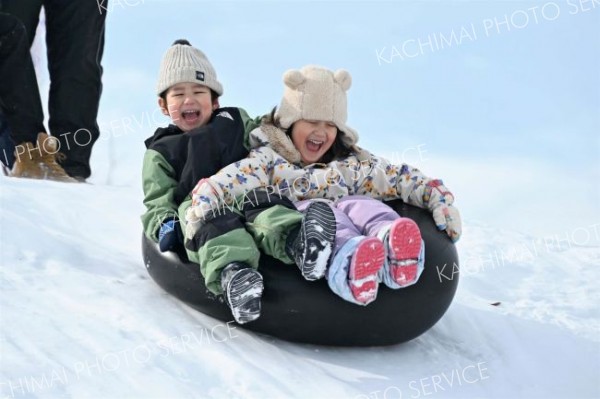 大きな雪山は子どもたちの格好の遊び場。大きな声を上げてタイヤチューブで滑り台を楽しむ子どもたち