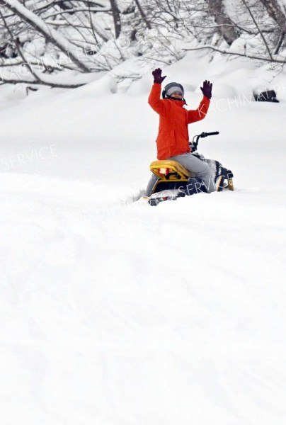 湖上では小型スノーモービルも体験できる。深雪に突っ込み立ち往生したスノーモービルから手を振る体験者