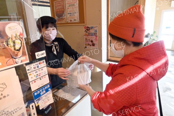 ろまん亭西１２条店でスタッフから商品を受け取る来店者（１４日午前１０時半ごろ）