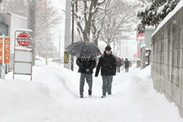 雪が降る中、登校する生徒たち（６日午前８時１５分ごろ、幕別札内文京町、村瀬恵理子撮影）