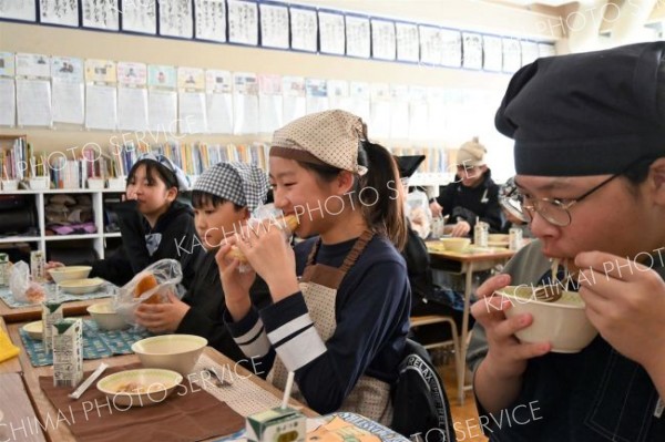 揚げパンをおいしそうに食べる下音小の６年生ら